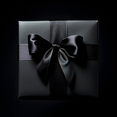 Black gift with a black ribbon on a black background 