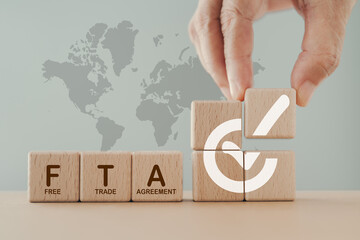 Hand arranged wooden cube blocks with approved signed and word FTA,  abbreviation for Free Trade...