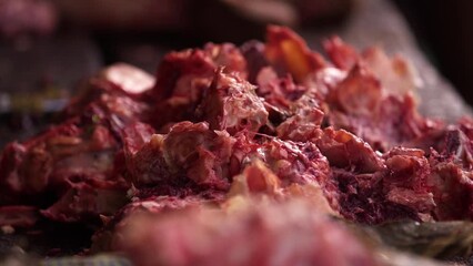 A market seller chops bones with a machete