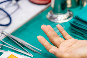 Finger with blood drop at finger from lancets for sample checking blood sugar level by blood...
