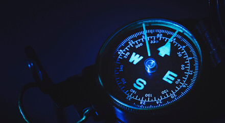 Close-up view of compass in blue tone. Finding direction in the dark. Vision of solution. © Win Nondakowit