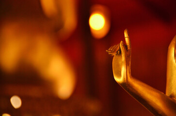 The hand of the Buddha image in the posture of holding an alms bowl. There is a golden small circle light between the fingers, look like  something miraculous happened.