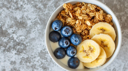 Delicious and healthy bowl of granola topped with fresh blueberries and sliced ​​bananas....