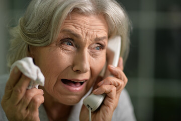 Portrait of sick senior woman talking on the phone