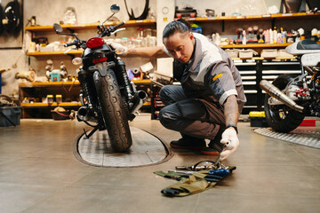 Mechanic choosing tool to use when fixing motorcycle