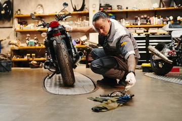 Fotobehang Mechanic choosing tool to use when fixing motorcycle © DragonImages