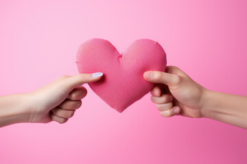 Two hands holding pink heart on pink background. Perfect for Valentine's Day or expressing love and affection in any context