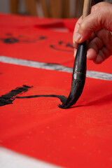 An old calligrapher writes couplets during the Chinese Year of the Dragon.
Translation: May you...