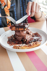 Chocolate waffle with chocolate gelato ice cream inside and sliced bananas with nuts on top.