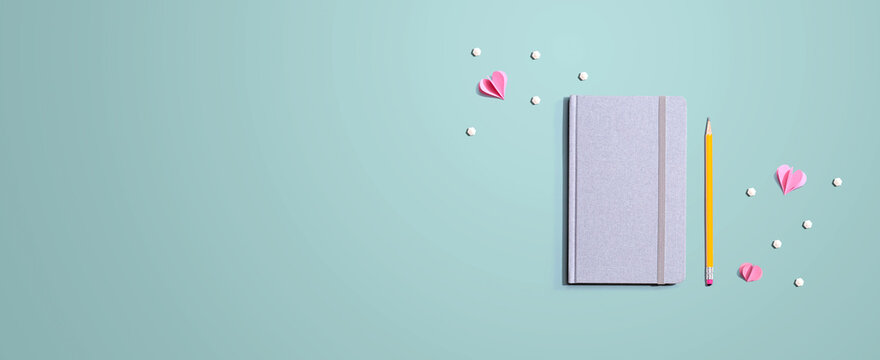 Gray notebook with paper hearts - flat lay