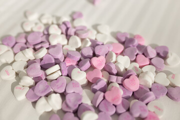 Background for Valentine's Day. Assorted pink, purple, white heart shaped candies with printed messages of love. Messages about kisses. Gift for Women's Day, March 8