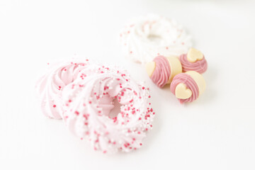 Heart-shaped pastries and candies on a white canvas close-up. Background for Valentine's Day, Easter. Gift for Women's Day, March 8th. Mockup