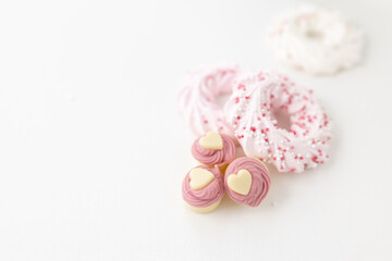 Heart-shaped pastries and candies on a white canvas close-up. Background for Valentine's Day, Easter. Gift for Women's Day, March 8th. Mockup