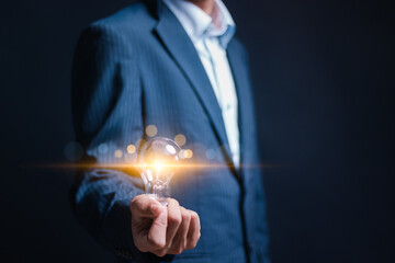 Business creativity and inspiration concept. Businessman holding bright light bulb for motivation...