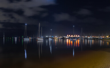 Lights and reflections across the Broadwater at night with yachts and the marina with its iconic...