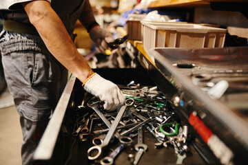 Cropped image of mechanic taking wrench from drawer