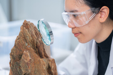 Expert female geologist or archaeologist working with rock, stone or fossil sample in paleontology,...