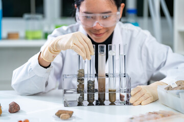 Ground researcher, geologist or archaeologist working with test tube of soil, rock, stone or fossil...