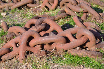 海岸公園の草むらに放置された太く古い錆びた鉄の鎖