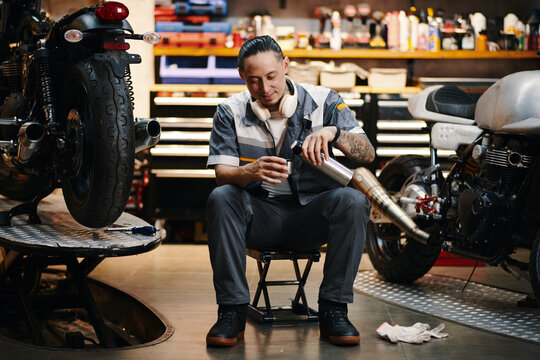 Repairman drinking coffee in his garage after finishing work on big project