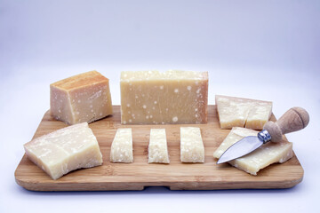 Italian Parmigiano Reggiano cheese on a wooden tray. Parmesan cheese.