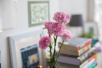 Pink carnations in a bottle on the table