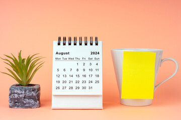 August 2024 Desk Calendar and a mug with adhesive note
