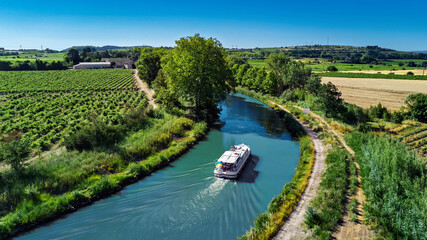 Aerial drone view of houseboat in Canal du Midi from above, family travel by boat, vacation in...