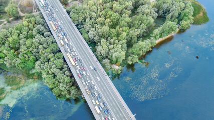 Aerial drone view of bridge road automobile traffic jam of many cars from above, city...