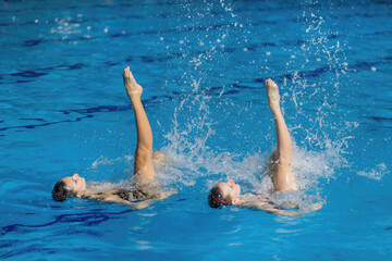Synchronized swimming duo gracefully dances through the water, showcasing seamless coordination and...