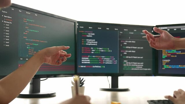Slow motion back end software developer engineer for computer programming working together on debugging writing computing code, solving complex algorithms display on monitor in office. Burgeoning