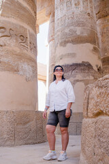 Fototapeta na wymiar Woman traveler explores the ruins of the ancient Karnak temple in the city of Luxor in Egypt.