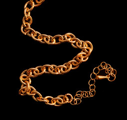 Gold chain isolated on black background. Close-up