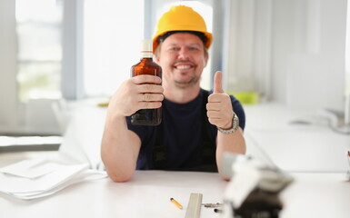 Arm of drunken worker in yellow helmet show OK gesture or confirm sign with thumb up closeup. Manual job workplace DIY inspiration fix shop hard hat industrial education profession career