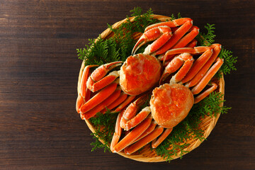 笊に盛ったボイルズワイガニの俯瞰撮影　木目背景