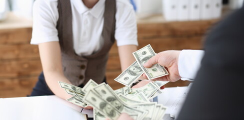 Businessman and business woman counting cash on the table at the office with hands very many...