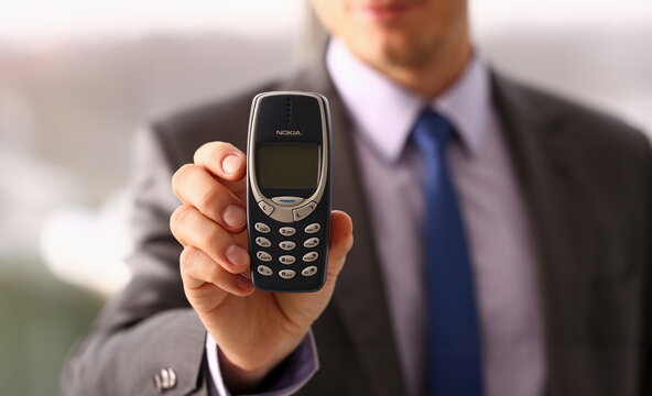 Illustrative Editorial Image. Minsk, Belarus, December 1, 2018 Businessman holding vintage phone nokia 3310 in hand