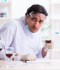 Male chemist examining wine samples at lab