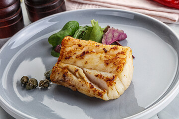Roasted cod fish steak with salad