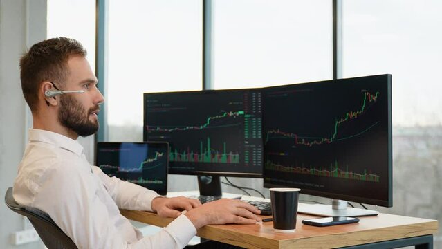 Concentrated crypto trader sitting in front of computers, making professional analysis of candlestick chart, creating strategy
