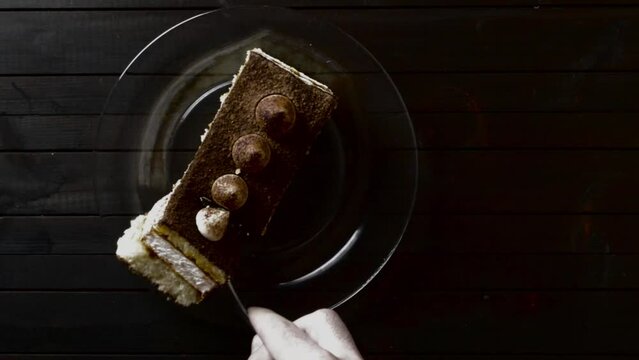 Top view, cutting a piece of truffle cake with a fork on a dark background.