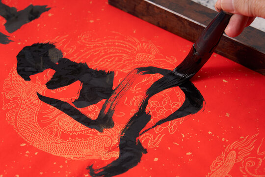 An old calligrapher writes couplets during the Chinese Year of the horse .Translation: The prancing horse welcomes the spring with elation.