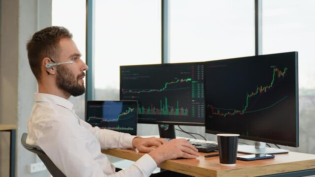 Happy stock or cryptocurrency trader is working by pc and celebrating success