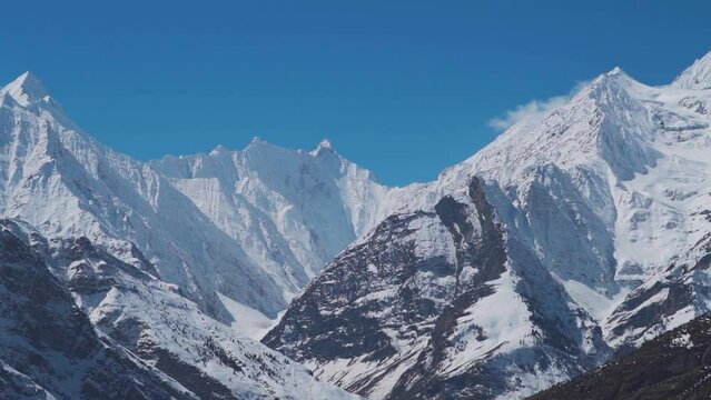 Landscape shot of snow covered Himalayan mountain peaks during the winter season as seen from Keylong at Lahaul Valley in Himachal Pradesh, India. Snowy mountain peaks during the winter season.