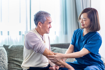Senior Asian man got medical service visit from caregiver nurse at home while preparing for physical therapy and using ointment rubbing for muscle pain in health care and pension welfare concept