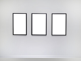Three transparent cutout vertical picture frames hanging on white wall, Wall art mockup set of 3 posters, blank space frame modern interior style, minimalist