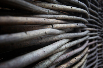 Fragment of a fence made of twigs. Rustic architecture and property protection. Close-up. Background. Space for text.