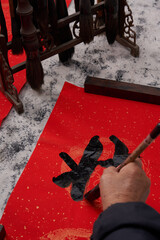 An old calligrapher writes couplets during the Chinese Year of the Dragon.
Translation: May you welcome the Spring and good luck in the Year of the Dragon.