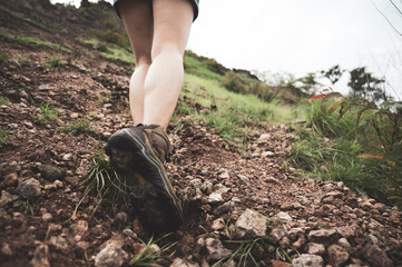 leg and foot step of female trekking, hiking or walking in jungle or mountain, concept of exploration recreation, sportive outdoor activity, wellbeing exercise, freedom outside journey, foot movement.