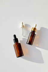 Organic daily skin care cosmetics. Vitamin C rerum, tea tree and essential argan oil.  Diffrend type of Skincare sebum glass dropper bottles with a pippette top view on white background.